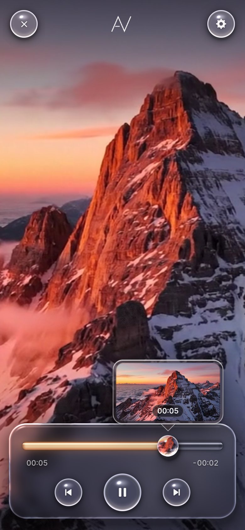The player on a phone: the mountain film in portrait, the close, AV and settings domes on top, and the glass panel at the bottom with the rod, the bead, the times and the previous, pause and next domes.